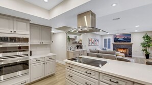 A modern kitchen with white cabinetry, a central island, and a built-in oven. - The Blue Lagoon: Where Space, Style and Comfort collide! (Las Vegas)