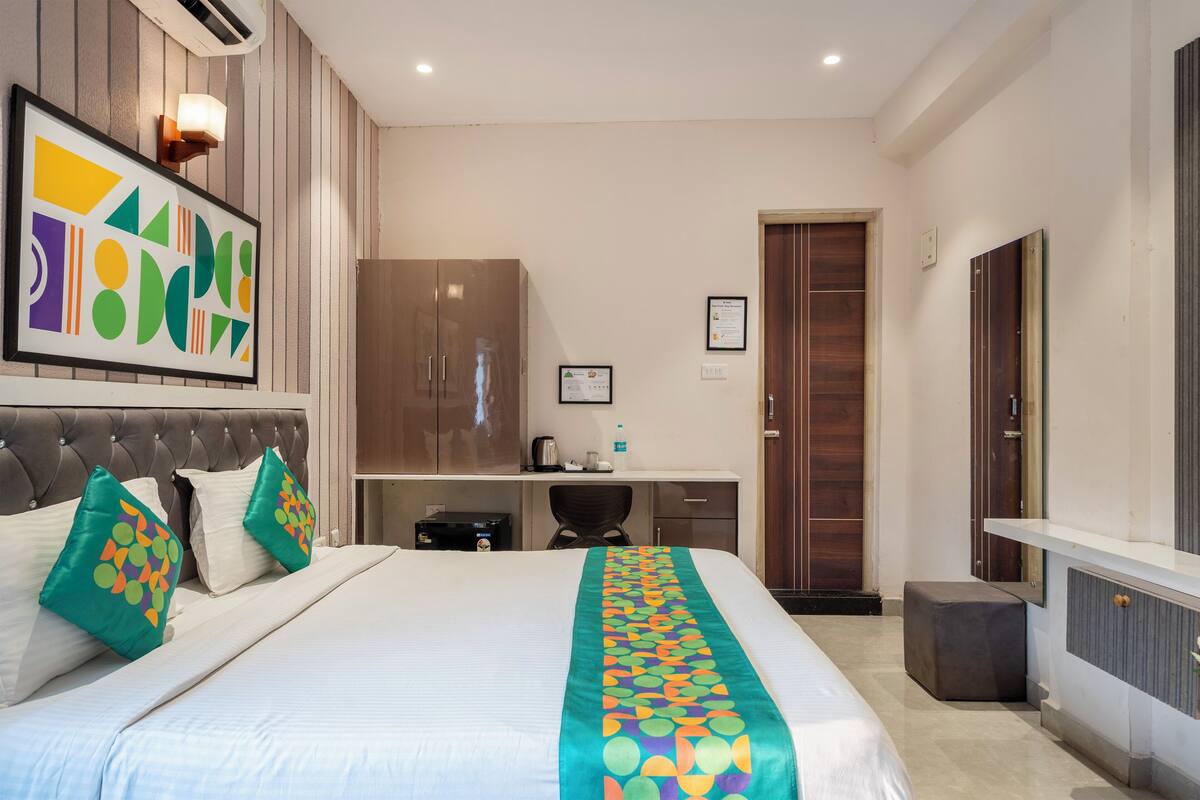 A hotel room with a bed, a desk, a wardrobe, and a bathroom.