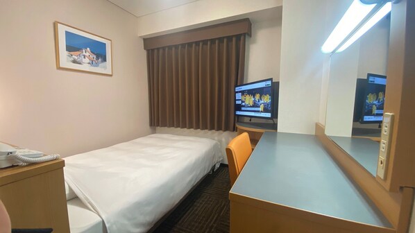 Habitación de hotel con cama, escritorio, silla, televisor, teléfono y un cuadro en la pared.