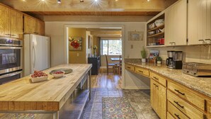 A kitchen with wooden cabinets, a granite countertop, and stainless steel appliances.