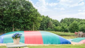 A picnic table with a vase of flowers and a colorful inflatable structure in the background. - 2 Person Holiday Park Home in Jelling (Jelling)