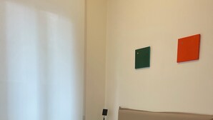 Une chambre à coucher avec un lit, une table de chevet et une lampe fixée au mur.
