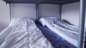 A single-bed room with a metal bunk bed structure, a patterned bedspread, and a plain wall. - 2 Person Holiday Park Home in Jelling (Jelling)