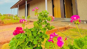 A building with a covered porch, large windows, and a door. - The Breeze Valley (Jaoli)