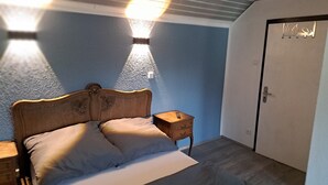 A bedroom with a bed, bedside tables, a wardrobe, and a wall-mounted light fixture. - 'Room near Nürburgring' with shared garden and Wi-Fi (Müsch)