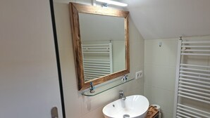 A bathroom with a wooden vanity, a white sink, a mirror with a wooden frame, a glass shelf, and a towel rack. - 'Room near Nürburgring' with shared garden and Wi-Fi (Müsch)