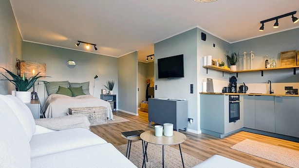 Eine moderne Wohnung mit Wohnzimmer, Küche, Essbereich und Schlafzimmer.