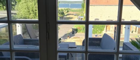 A room with a large window overlooking a deck with outdoor furniture.