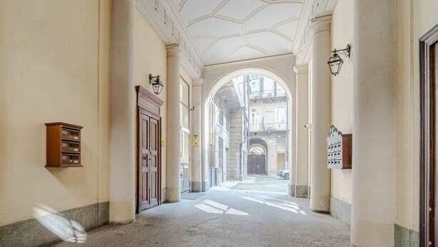 A corridor with columns, a wooden cabinet, and a door. - GuestHost - Lovely Retreat for 2 - 400 m far from Porta Nuova (Torino)
