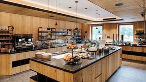 A modern kitchen with wooden cabinetry, a central island with food items, and pendant lighting.
