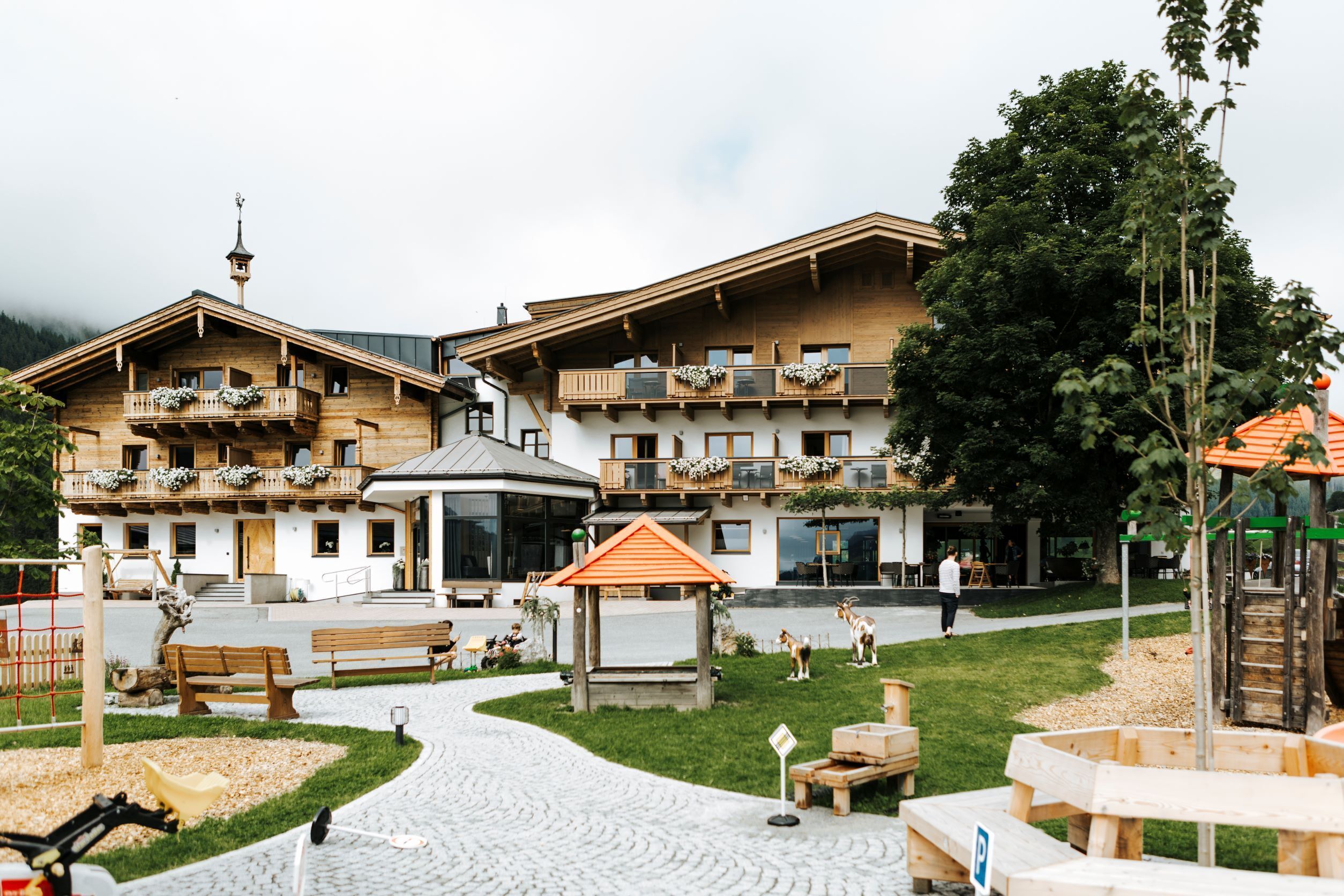 A wooden building with balconies, a gazebo, and outdoor seating areas.