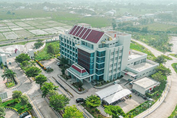 An aerial view of a modern building with a flat roof, surrounded by greenery and a parking lot. - De Balen Soultan Hotel (Jonggat)