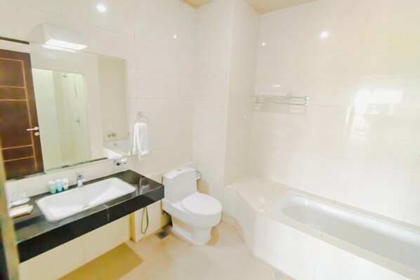 A modern bathroom with a large sink, toilet, and bathtub.