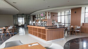 A modern hotel lobby with a central island counter, dining tables, and chairs. - De Balen Soultan Hotel (Jonggat)