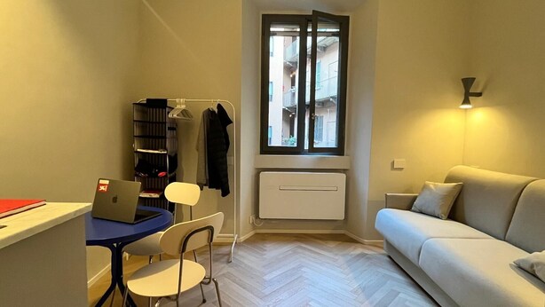 A compact living space with a desk, chair, laptop, and a sofa. - Design micro apartment in the Porta Venezia Design District (Milano)