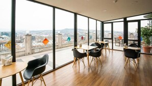 Un intérieur moderne avec de grandes fenêtres donnant sur la ville, un plancher en bois et un mobilier contemporain.