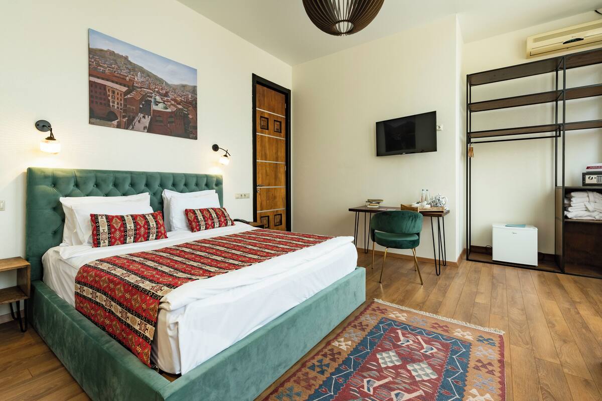 Une chambre à coucher bien rangée, avec un grand lit, une télévision et une armoire.