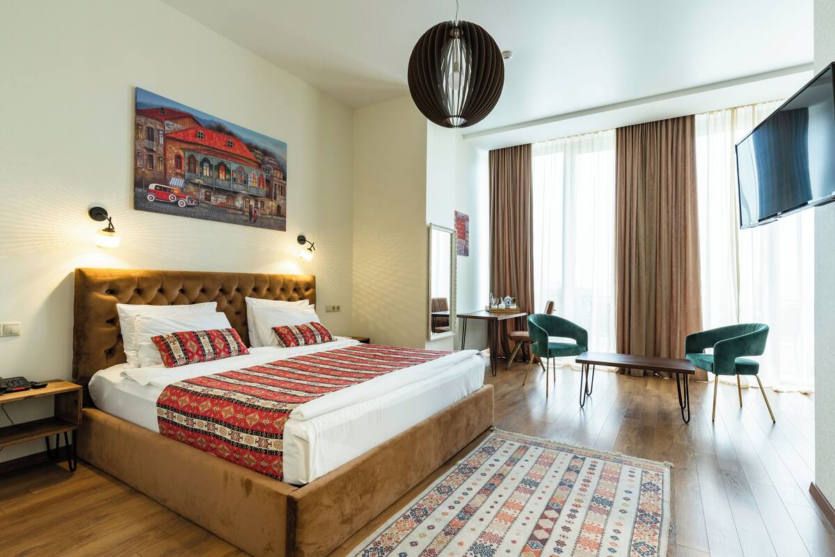 Une chambre d’hôtel avec un grand lit, un bureau et une télévision.