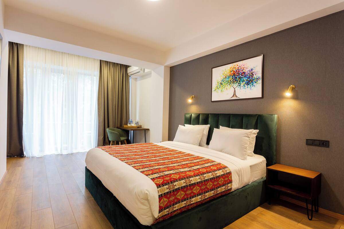 Une chambre d’hôtel avec un grand lit, un bureau et une chaise.