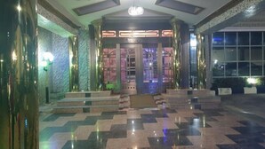 A lobby with a patterned floor, a central door, and a chandelier. - Trophy Hotel LTD (Kaduna)