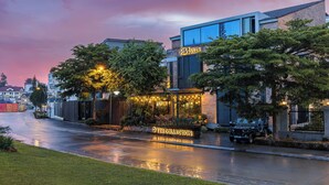 A modern building with a sign 'RIVVILLA' and a 'TR COLLECTION' sign below. - The K'rin Villa (Xuan Huong - Da Lat)