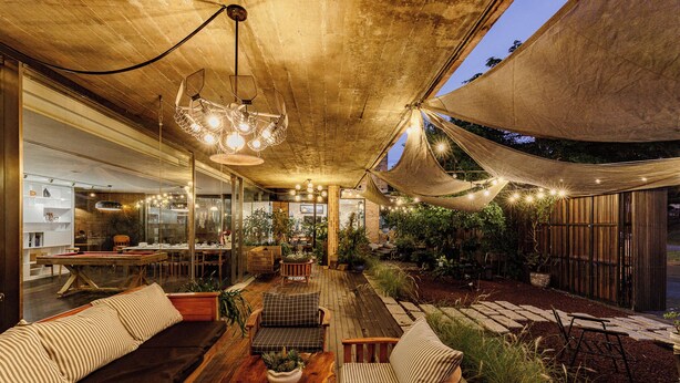 A modern outdoor dining area with wooden furniture, a pool table, and string lights. - The K'rin Villa (Xuan Huong - Da Lat)