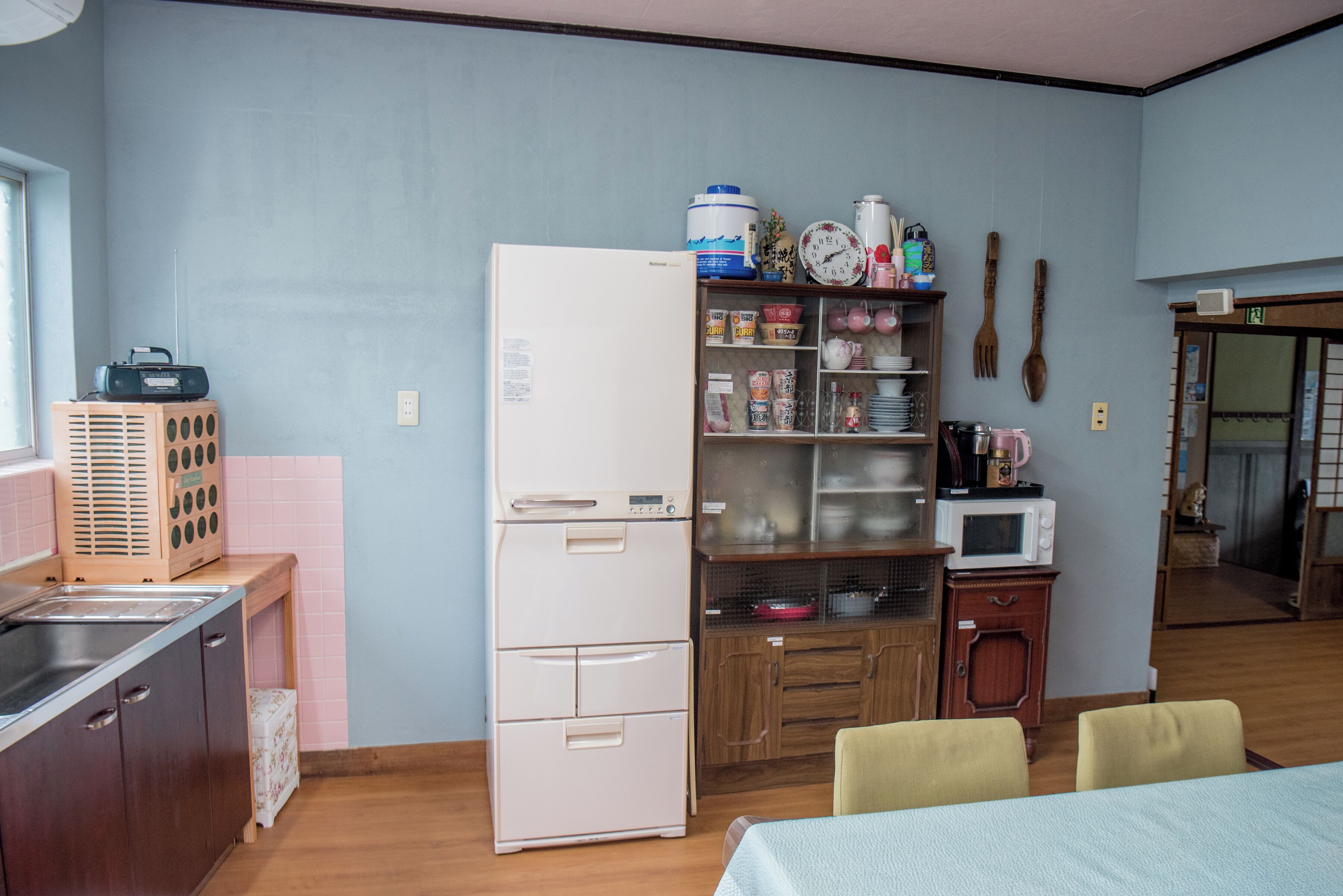 A compact kitchen with a refrigerator, microwave, and wooden cabinets.