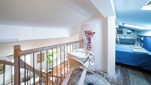 A bedroom with a blue bedspread, a wooden staircase, and a view of the kitchen. - 3* family duplex near the sea, Spain and the mountains. Pets allowed (Le Boulou)