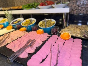 A buffet with various food items including sliced meats, fruits, and vegetables. - Aven Hotel (Istanbul)