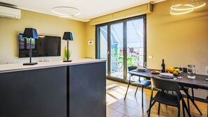 Et moderne køkken med spiseplads, store vinduer og et fladskærms-tv.