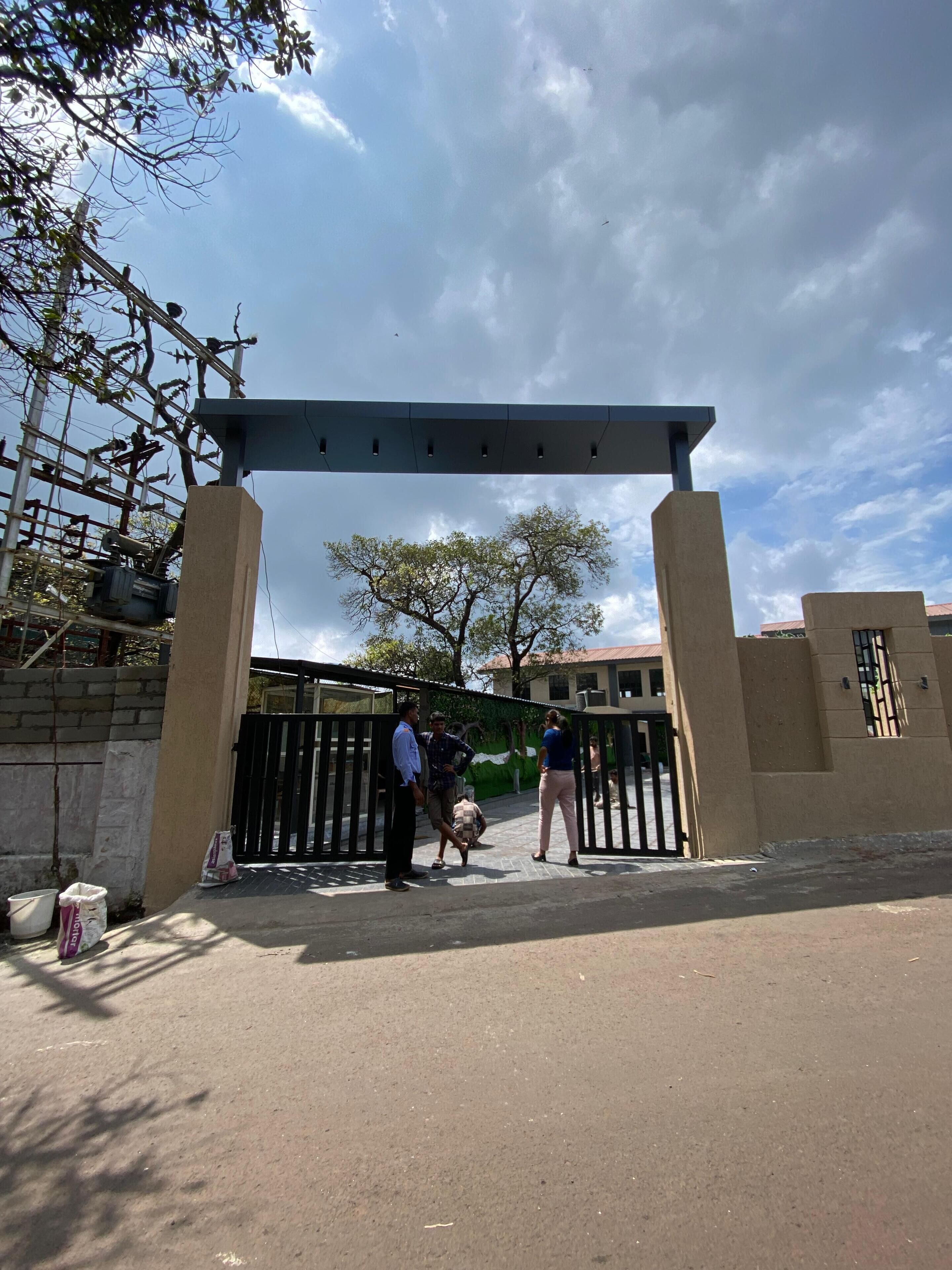A gated entrance with a metal gate and a concrete archway.