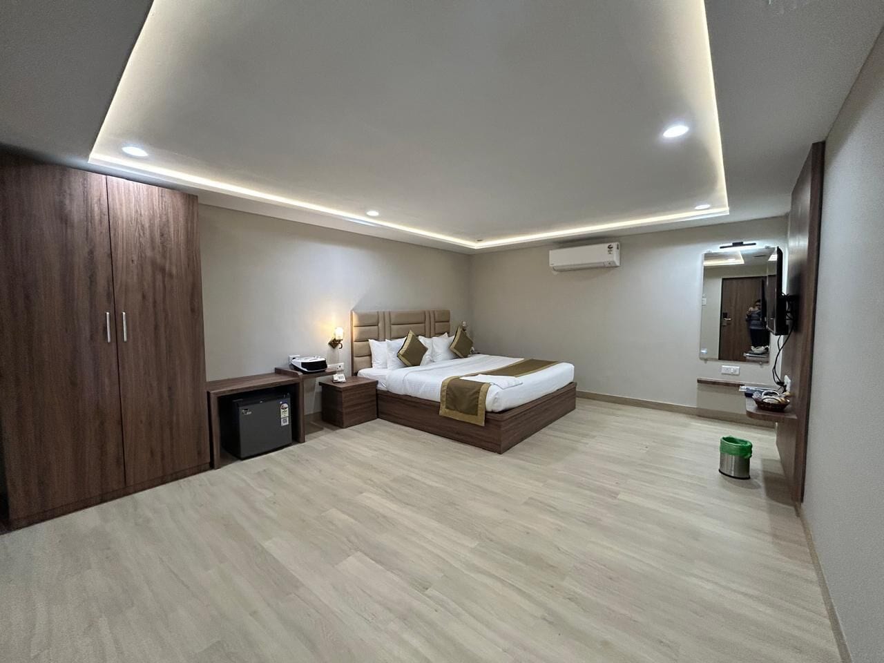 A modern bedroom with a bed, bedside tables, a wardrobe, and a small desk.