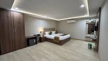 A modern bedroom with a bed, bedside tables, a wardrobe, and a small desk.