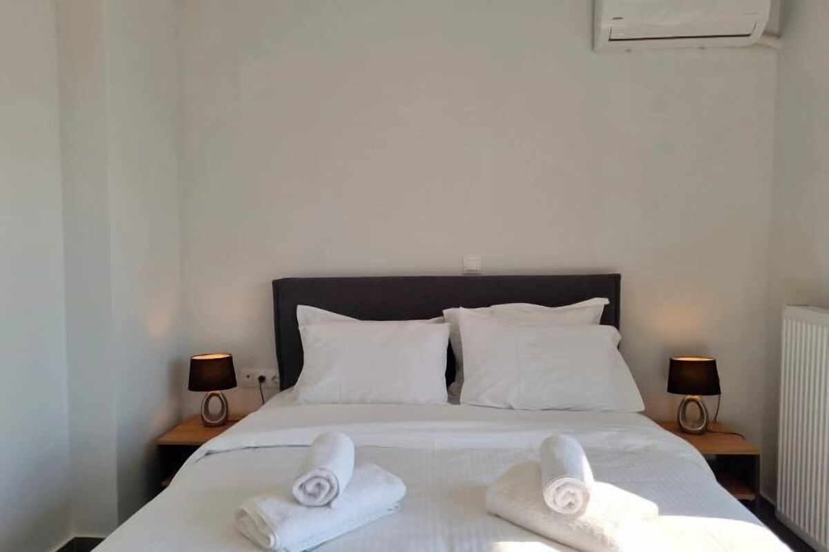 A hotel room with a large bed, two bedside tables with lamps, and a radiator.