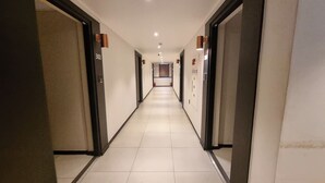 Un largo y estrecho pasillo de hotel con puertas numeradas 302 y 303.