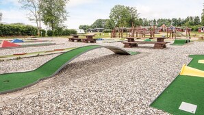 A playground with various play structures, including a seesaw, climbing area, and a small slide. - 4 Person Holiday Park Home in Jelling (Jelling)
