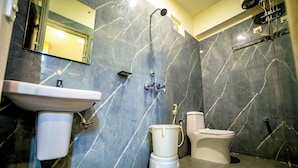 Une salle de bain avec un mur en marbre, un lavabo, des toilettes et une douche.