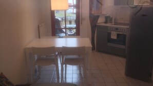 A compact kitchen with a dining area, a built-in oven, and a refrigerator. - Unique apartment in the Hundertwasserhaus in the center of Plochingen

 (Plochingen)