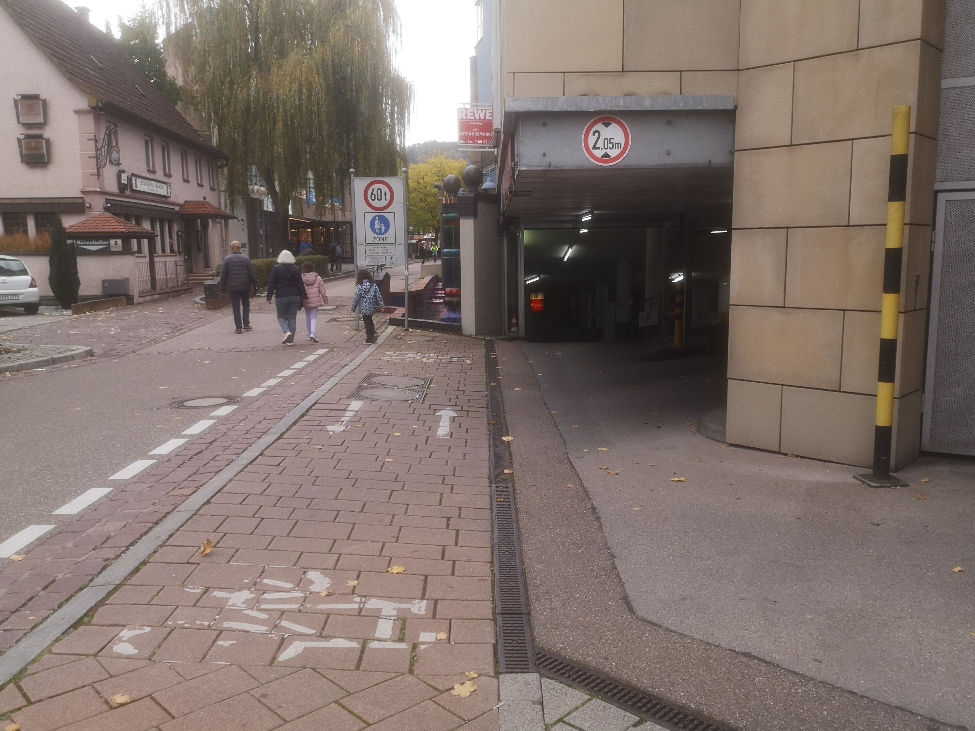 Eine Straße mit Fußgängerüberweg, einem Verbotsschild und einem Hauseingang.
