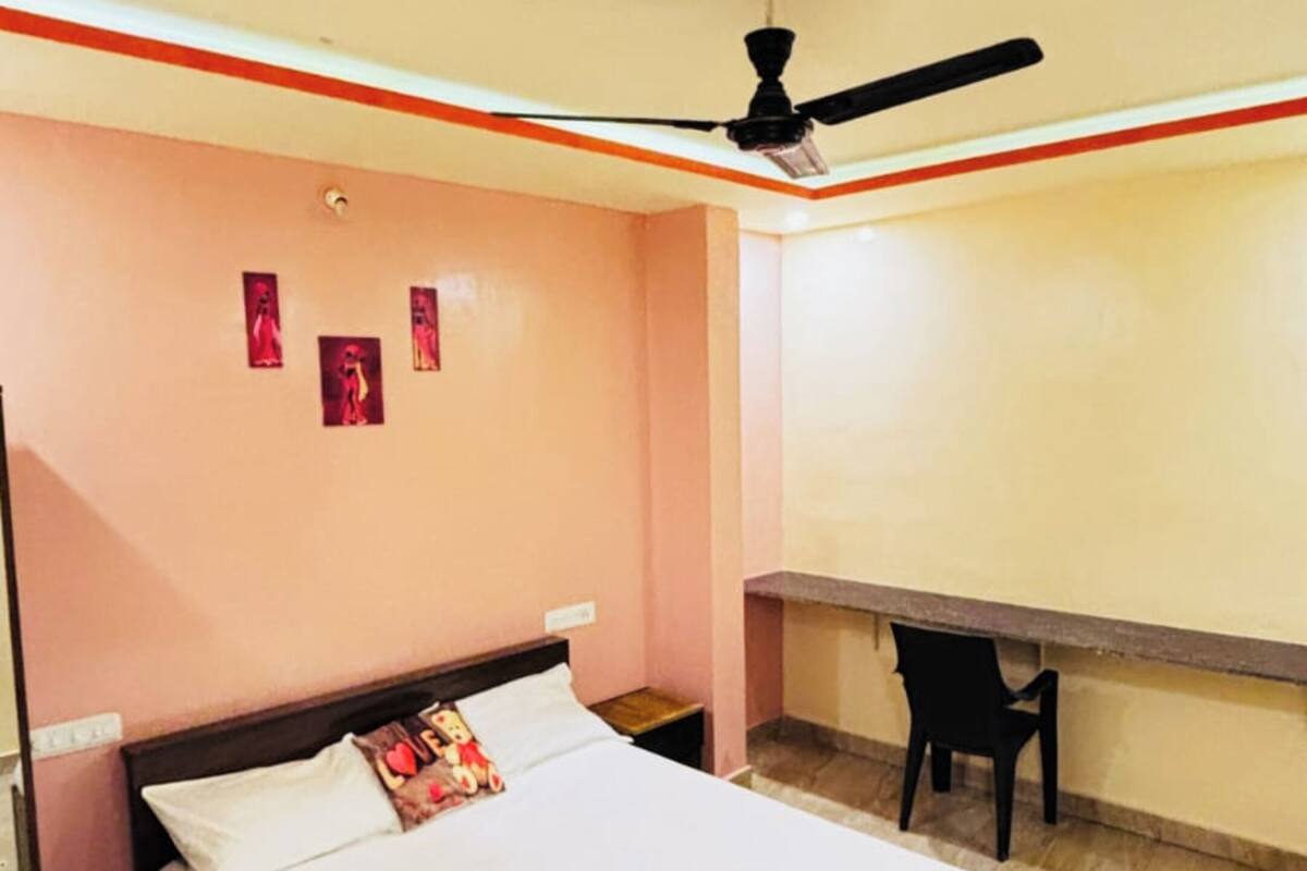 Ein Schlafzimmer mit Bett, Schreibtisch und Deckenventilator.