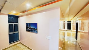 A hallway with a painting of a snowy landscape, a window, and a door.