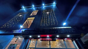 The exterior of the Royal Ruby Hotel with illuminated signage and a digital display indicating 'ROOMS'.
