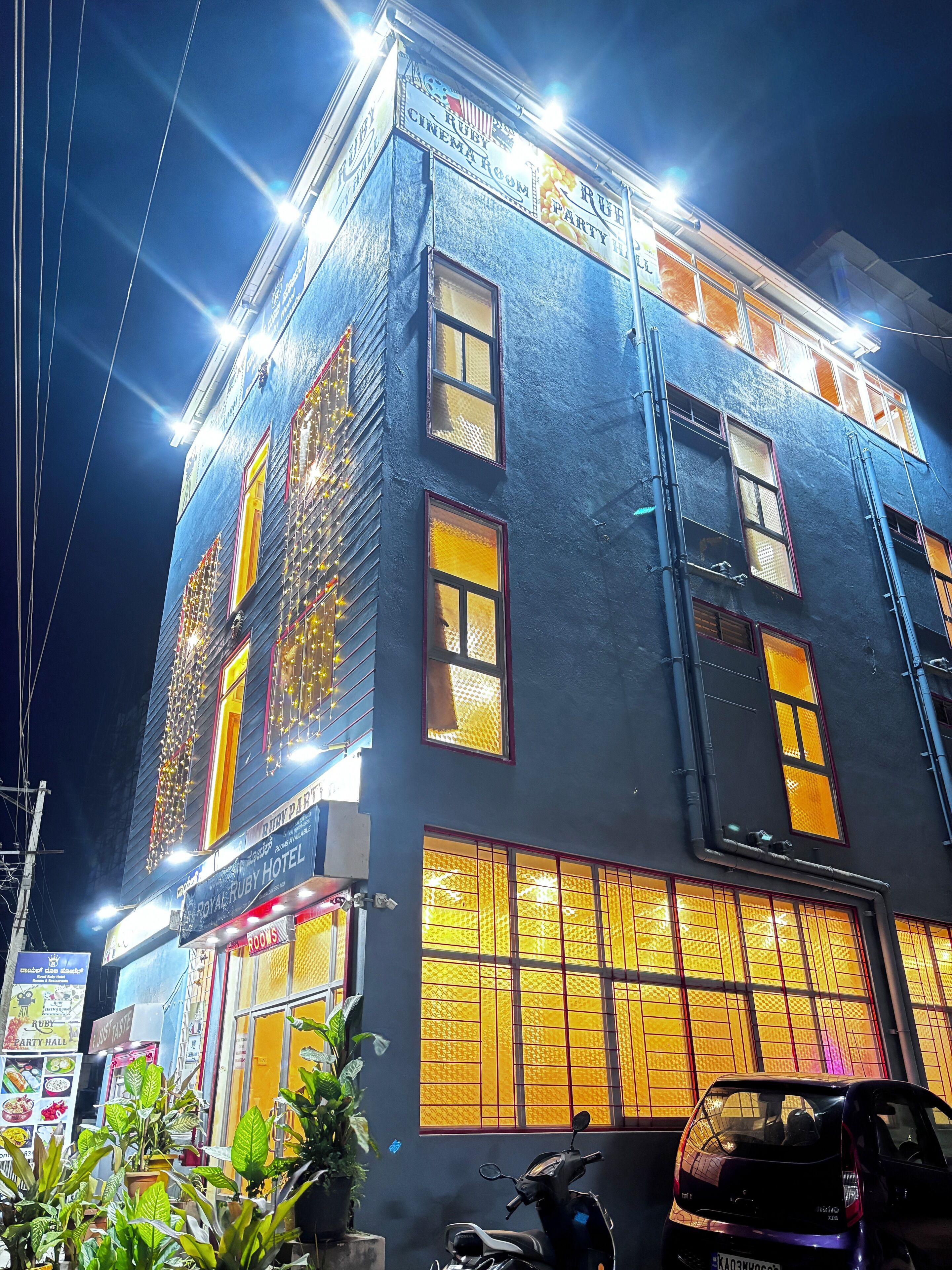 A building with multiple windows, some with yellow-tinted glass, and signs indicating a cinema room and a party hall.