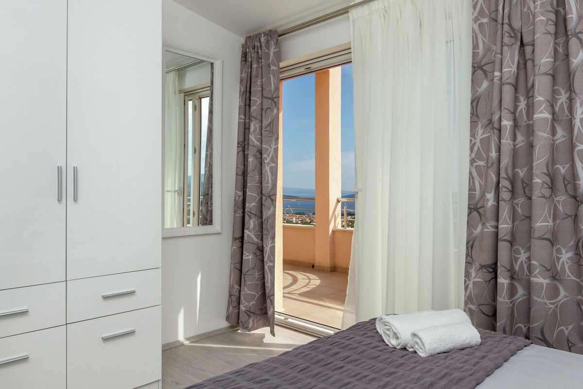 Une chambre à coucher avec un lit, une armoire et un balcon offrant une vue.