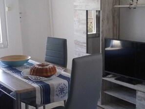 A dining area with a table, chairs, a television, and a window. - Striking Holiday Home in Sternberg With Jetty (Sternberg)