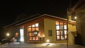 A two-story building with large windows and a snow-covered ground.