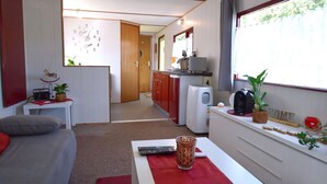 Ein kompaktes Wohnmobil-Interieur mit einer Küchenzeile, einem Essbereich und einer Wohnsitzecke.