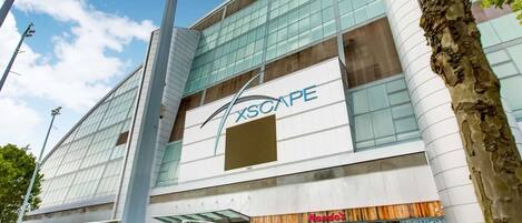 Un edificio moderno con fachada de vidrio y un letrero que dice "XSCAPE".