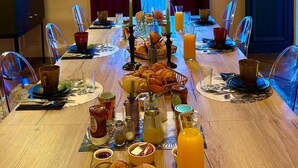 Un buffet de petit-déjeuner avec des croissants, des viennoiseries et du jus d’orange.