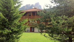 A chalet with a balcony, surrounded by trees and mountains in the background. - Spacious Chalet With Garden Near Ski Area in Tyrol (San Giovanni di Fassa)